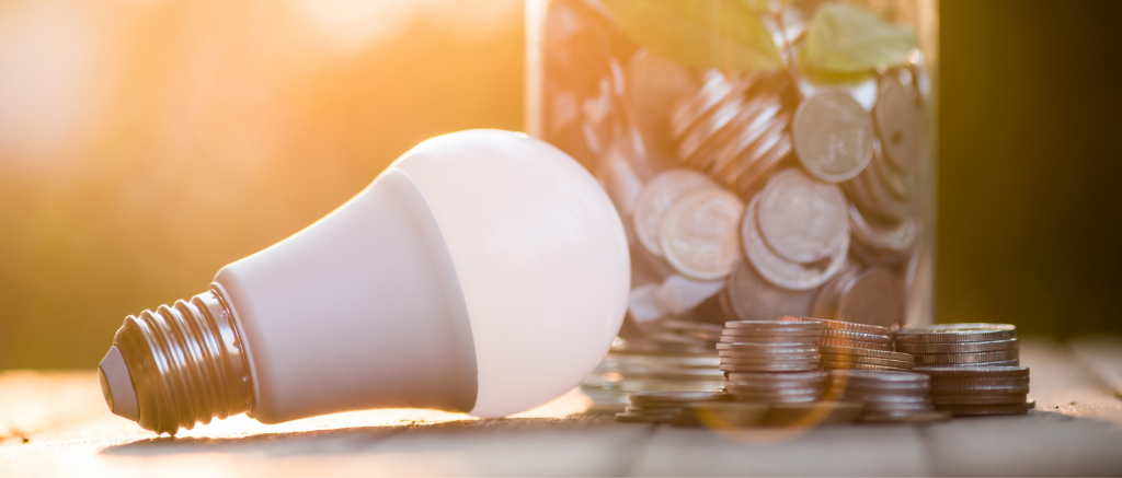 A light bulb next to a stack of coins